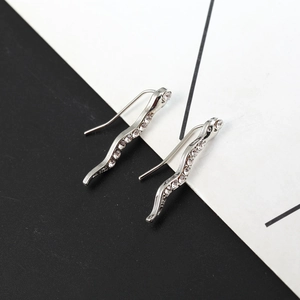 Dettaglio ravvicinato di un orecchino a serpente in argento con zirconi micro-pave lucidi