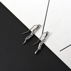 Dettaglio degli orecchini a forma di serpente in argento con pavé di strass scintillanti
