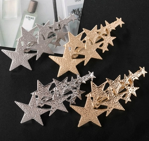 Detailed close-up of four star-shaped hairpins with hammered gold and silver metal textures