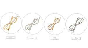 Detail of four bow-shaped metal hair clips in gold and silver with a twisted texture