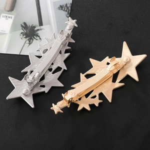 Detailed back view showing metal duckbill clip structure of gold star hair pin