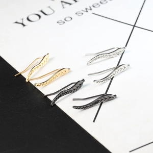 Set of leaf-shaped ear crawlers in gold, silver, and black finishes on a split background