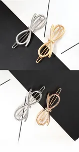 Macro view of metallic bow hair clips showing textured rope pattern in gold and silver