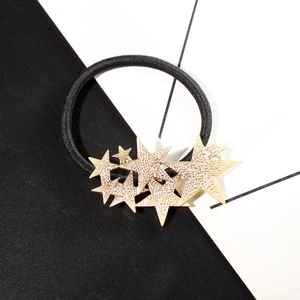 Élastique à cheveux avec pendentifs étoiles dorées et zircons sur fond géométrique chic