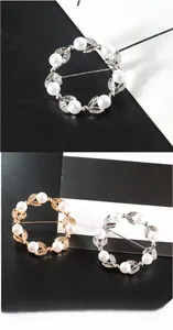 Gros plan sur d'élégantes broches perles et feuilles en finitions or et argent