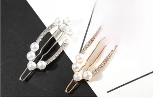 Détail de l'incrustation de perles et strass sur barrettes dorées et argentées