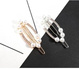 Détail de pinces à cheveux dorées et argentées avec perles et strass brillants