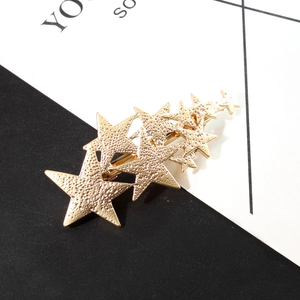Gold star hair clip with textured matte finish and multiple layered five-point stars