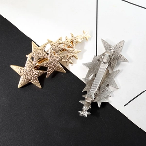 Star-shaped hair clips in gold and silver finish with frosted textured metal surface