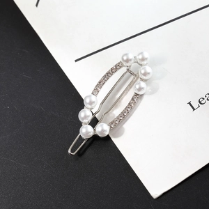 Barrette géométrique argentée élégante avec perles et strass sur un fond bicolore moderne