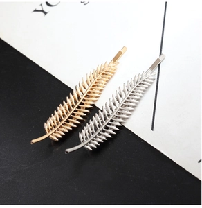 Detailed close-up of gold and silver leaf hair clips with intricate vein textures