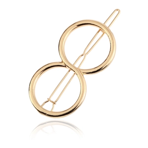 Macro detail of golden zinc alloy hair clip featuring double circle geometric figure 8 design