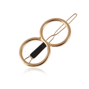 Detail view of gold metal hair clip with double circle infinity design and black rubber grip