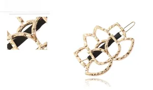 Detail of golden hollow lotus hair clip with hammered texture and secure black rubber grip