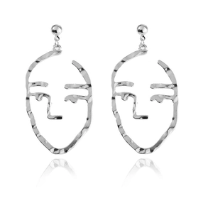 Detailed macro view of silver abstract face earrings with hammered texture finish