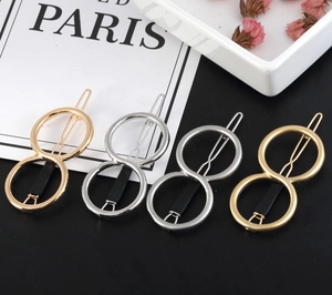Detail view of four-piece geometric metal hair clips set in gold and silver finishes