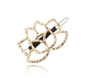 Detailed close-up of golden lotus hair clip with hammered texture and hollow design