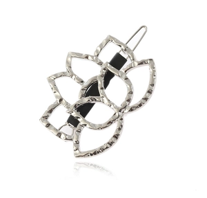 Detailed close-up of hollow silver lotus hair clip with hammered texture and grip