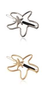 Detailed view of silver and gold hollow starfish hair clips with black accents