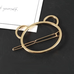 Barrette à cheveux minimaliste dorée en forme de tête d'ours sur fond noir classique