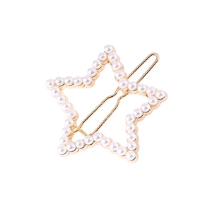 Detail of a hollow star-shaped hair clip with gold metal plating and white pearls