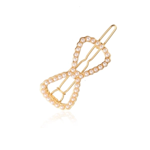 Elegant gold alloy bow hair clip featuring detailed white pearls on a reflective white base