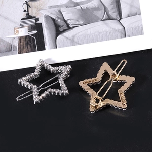Detail of silver rhinestone star hair clip and golden metal spring clip mechanism
