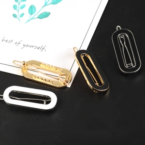 Minimalist oval alloy hair clips in black, white, and gold finishes displayed on card