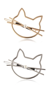 Détail de barrettes chat ajourées en or et argent avec une perle blanche élégante