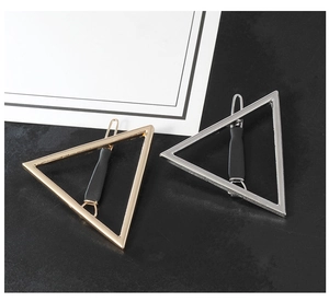 Vue détaillée de barrettes géométriques triangle en or et argent avec grips antidérapants