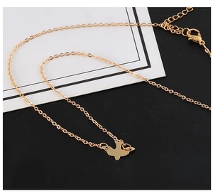 Detailed macro view of the gold dove pendant with adjustable lobster clasp chain