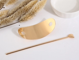 Detailansicht eines goldenen Haarstab-Sets mit Herz-Element und gebogener Haarspange