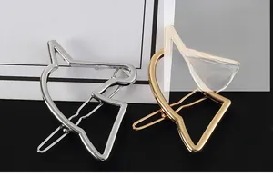 Detail of minimalist gold and silver cat-shaped cutout hairpins with shiny metal finish