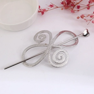 Detail of silver alloy hollow hair clip and heart pin with elegant brushed metal texture