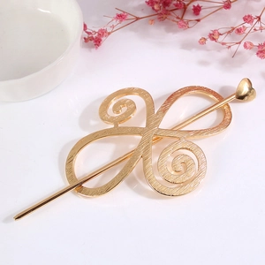 Detailed view of golden alloy hair pin featuring hollow swirl design and heart motif