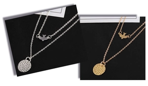 Close-up of double layer necklace featuring swallow bird pendant and hammered metal disc