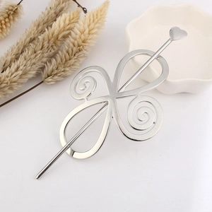 Detail view of silver hollow hair stick with Celtic spiral frame and heart-shaped pin