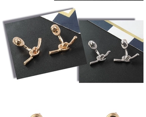 Gros plan détaillé de boucles d'oreilles nœud polies en or et argent au style minimaliste