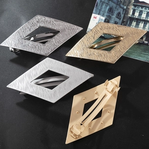 Détail de barrettes losanges en métal à texture brossée en quatre couleurs métallisées
