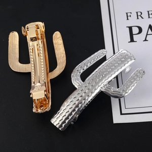 Golden and silver cactus-shaped metal hair clips with textured finish on display