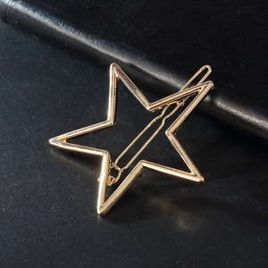 Barrette à cheveux étoile dorée évidée en alliage poli sur fond noir élégant et chic