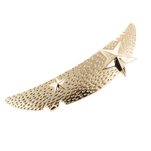 Detail of matte gold moon crescent hair clip with star accents and textured surface