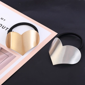 Minimalist heart-shaped metal hair tie in matte gold and silver finish with elastic band