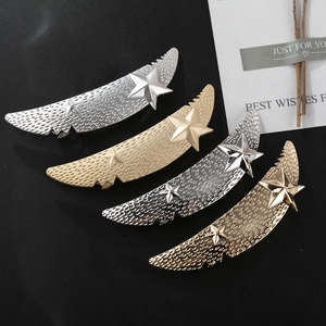 Detailed macro view of four metallic hair clips with star textures on a dark background