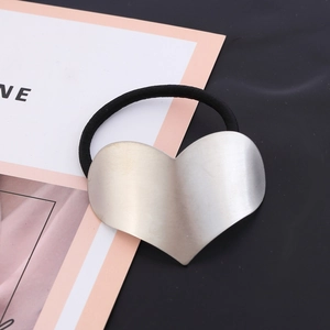Minimalist silver heart metal hair tie with black elastic band on elegant background