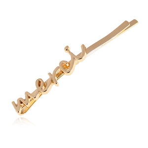 Vue macro d'une barrette dorée en alliage avec inscription merci polie sur fond blanc