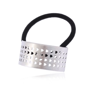 Élastique à cheveux avec cœur ajouré en argent et bande noire sur fond blanc