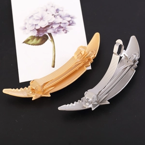 Matte gold and silver moon shaped textured hair clips in feather leaf design