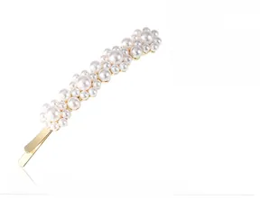 Detailed view of elegant white pearls set on a high-quality light gold metal hair clip