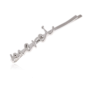 Détail de la barrette en métal argenté avec inscription merci sur fond blanc